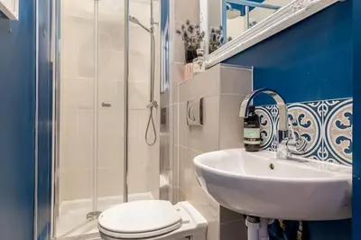 a bathroom with a sink and a toilet and a shower at Beautiful Victorian Apartment close to the Botanical gardens, Free parking! in Edinburgh