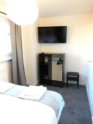 a room with two beds and a flat screen tv at No 54 - New & delightful 3 bed house in East Kilbride in Glasgow