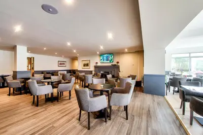 a restaurant with tables and chairs in a room at Onich Hotel & Lochside Beach Pods in Onich