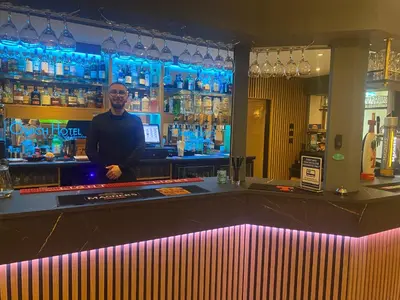 a man standing behind a bar in a bar at Onich Hotel & Lochside Beach Pods in Onich