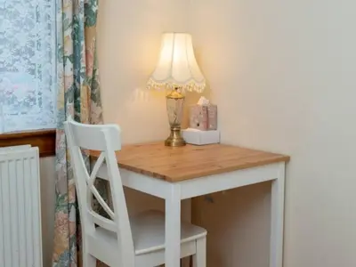 a white desk with a lamp and a white chair at Spacious Murrayfield Flat - Pass the Keys in Edinburgh