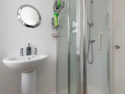 a bathroom with a sink and a shower with a mirror at Spacious Murrayfield Flat - Pass the Keys in Edinburgh