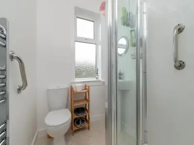 a bathroom with a shower and a toilet and a window at Spacious Murrayfield Flat - Pass the Keys in Edinburgh
