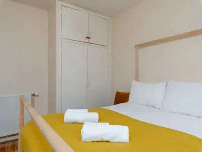 a bedroom with a yellow bed with two towels on it at Spacious Murrayfield Flat - Pass the Keys in Edinburgh