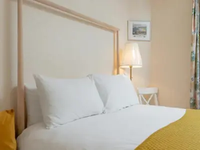 a bedroom with a bed with white pillows at Spacious Murrayfield Flat - Pass the Keys in Edinburgh