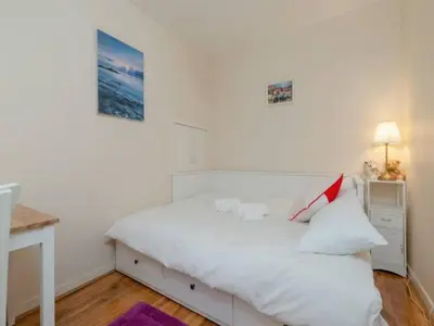 a white bedroom with a bed and a desk at Spacious Murrayfield Flat - Pass the Keys in Edinburgh