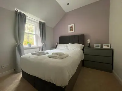 a bedroom with a large bed with two towels on it at Carronvale. 3 Bedroom Oban Apartment. in Oban
