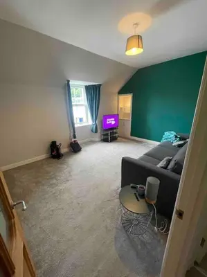 a living room with a couch and a tv at Carronvale. 3 Bedroom Oban Apartment. in Oban