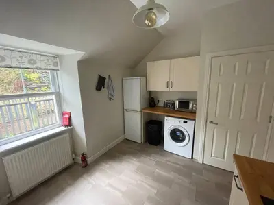 a kitchen with a white refrigerator and a washing machine at Carronvale. 3 Bedroom Oban Apartment. in Oban