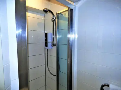 a shower with a phone in a bathroom at Grassmarket Studio in Edinburgh