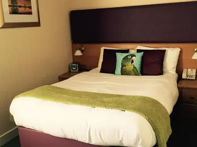 a large bed in a hotel room with at Uplawmoor in Uplawmoor
