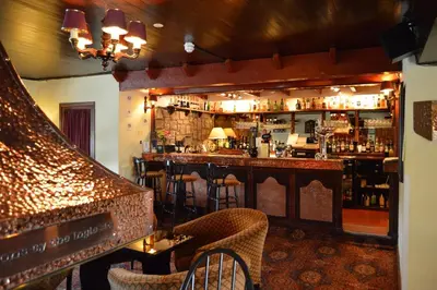 a bar with chairs and a counter in a room at Uplawmoor in Uplawmoor