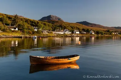 a wooden boat sitting in the middle of a body of water at Seaview Cottage in Isle of Jura