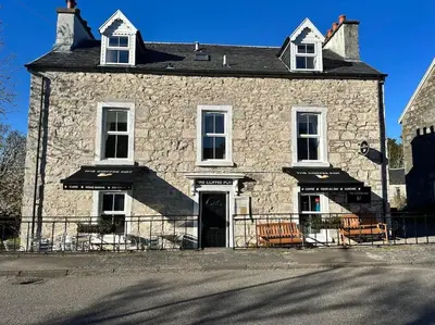 a large stone building with a door on a street at Argyll House Ben More in Salen