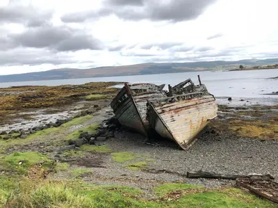 two old boats sitting on a beach near the water at Argyll House Burnside in Salen