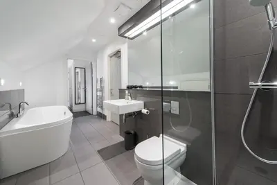 a bathroom with a toilet and a sink and a shower at Cool urban apartment with stunning Castle views in Edinburgh