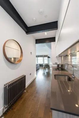 a kitchen with a sink and a mirror on the wall at Cool urban apartment with stunning Castle views in Edinburgh