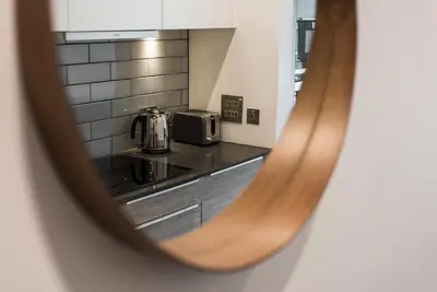 a view of a kitchen through a mirror at Cool urban apartment with stunning Castle views in Edinburgh