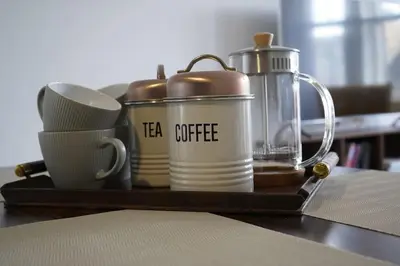 a tray with tea cups and coffee on a table at Falkirk City Centre Stylish Two-Bedrooms Apartment in Falkirk
