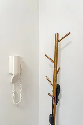 a phone hanging on a wall next to a wooden pole at The Merchants Gem - 2Bed & Free Parking in Glasgow