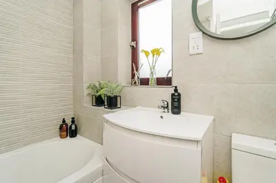 a bathroom with a white sink and a mirror at The Merchants Gem - 2Bed & Free Parking in Glasgow