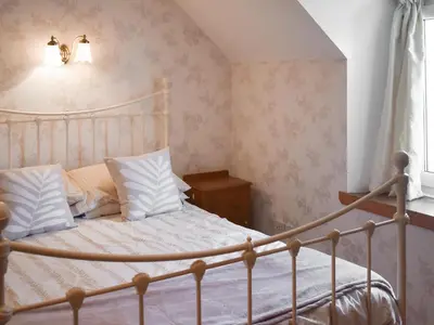 a bedroom with a bed with white sheets and pillows at Bayview in Kentallen
