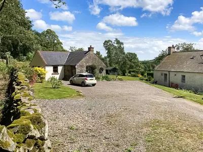 a white car parked in front of a house at The Clachan Bothy in Drumpark