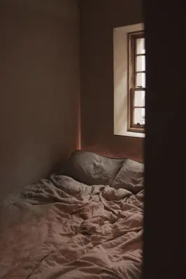an unmade bed in a room with a window at Loggia Studio in Edinburgh