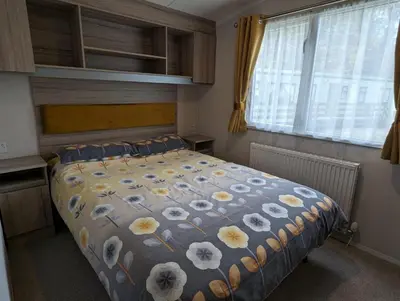 a bedroom with a bed with flowers on it at The Ardennes 66 in Dunoon