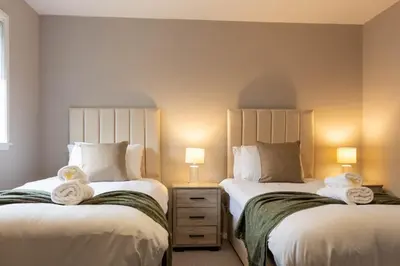 two beds sitting next to each other in a bedroom at Grove House in Queensferry