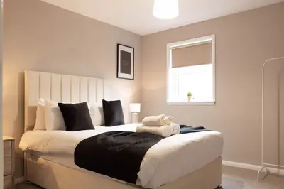 a bedroom with a bed with a stuffed animal on it at Grove House in Queensferry