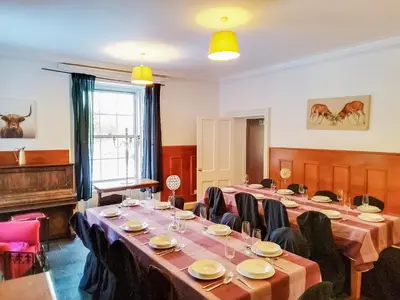 a conference room with tables and chairs and a piano at Colzium Farmhouse in Blitterlees