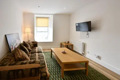 a living room with a couch and a coffee table at Troon Portland Apt B in Troon