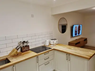 a kitchen with white cabinets and a counter top at Oban Lorne Apartment in Oban