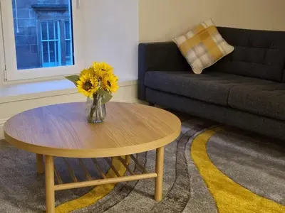 a living room with a vase of flowers on a table at Oban Lorne Apartment in Oban