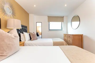 a bedroom with two beds and a mirror at SECC Hydro Executive 7 Apartment in Glasgow