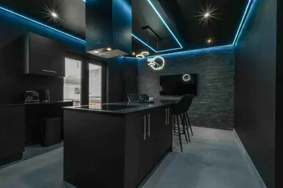 a kitchen with black cabinets and blue lighting at Luxury Couples Get-Away Glasgow in Knightswood
