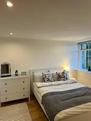 a bedroom with a bed with a dresser and a window at The Inverleither in Edinburgh