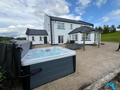 a hot tub in front of a house at Coylebrae House in Ayr