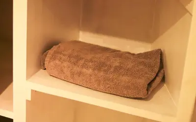 a towel is sitting on a shelf in a closet at 1 Bedrooms Flat in Central Edinburgh Haymarket, Heart of Edinburgh Flat Sleeps 4 in Edinburgh