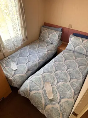 two beds in a small room with a window at Atlas 2 Bedroom Caravan - Located in Uddingston, Glasgow at Maryville Caravan Site in Uddingston