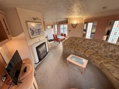 a living room with a couch and a fireplace at Atlas 2 Bedroom Caravan - Located in Uddingston, Glasgow at Maryville Caravan Site in Uddingston