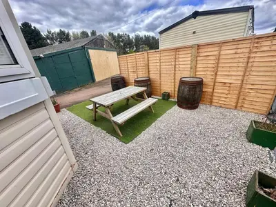 a backyard with a picnic table and a fence at Atlas 2 Bedroom Caravan - Located in Uddingston, Glasgow at Maryville Caravan Site in Uddingston