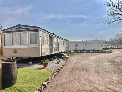 a tiny house is parked in a yard at Atlas 2 Bedroom Caravan - Located in Uddingston, Glasgow at Maryville Caravan Site in Uddingston