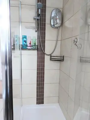 a bathroom with a shower with a glass door at The Relish - ground floor flat in Largs in Largs