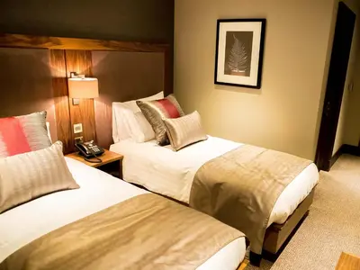 a hotel room with two beds and a telephone at Busby Hotel in Busby
