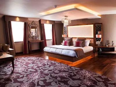 a bedroom with a large bed and a large rug at Busby Hotel in Busby