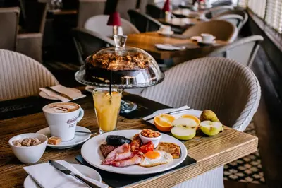 a table with a plate of breakfast food on it at Busby Hotel in Busby