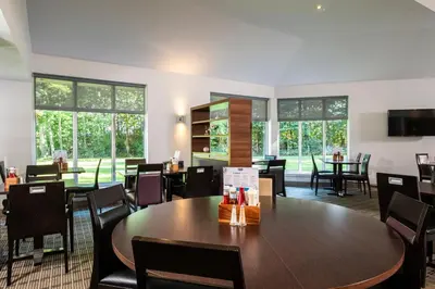 a dining room with tables and chairs and windows at Holiday Inn Express Stirling by IHG in Stirling