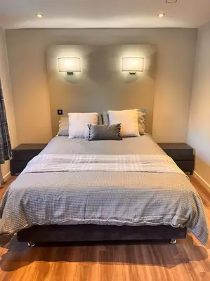 a bedroom with a large bed with two pillows at Gleneagles Apartment in Auchterarder